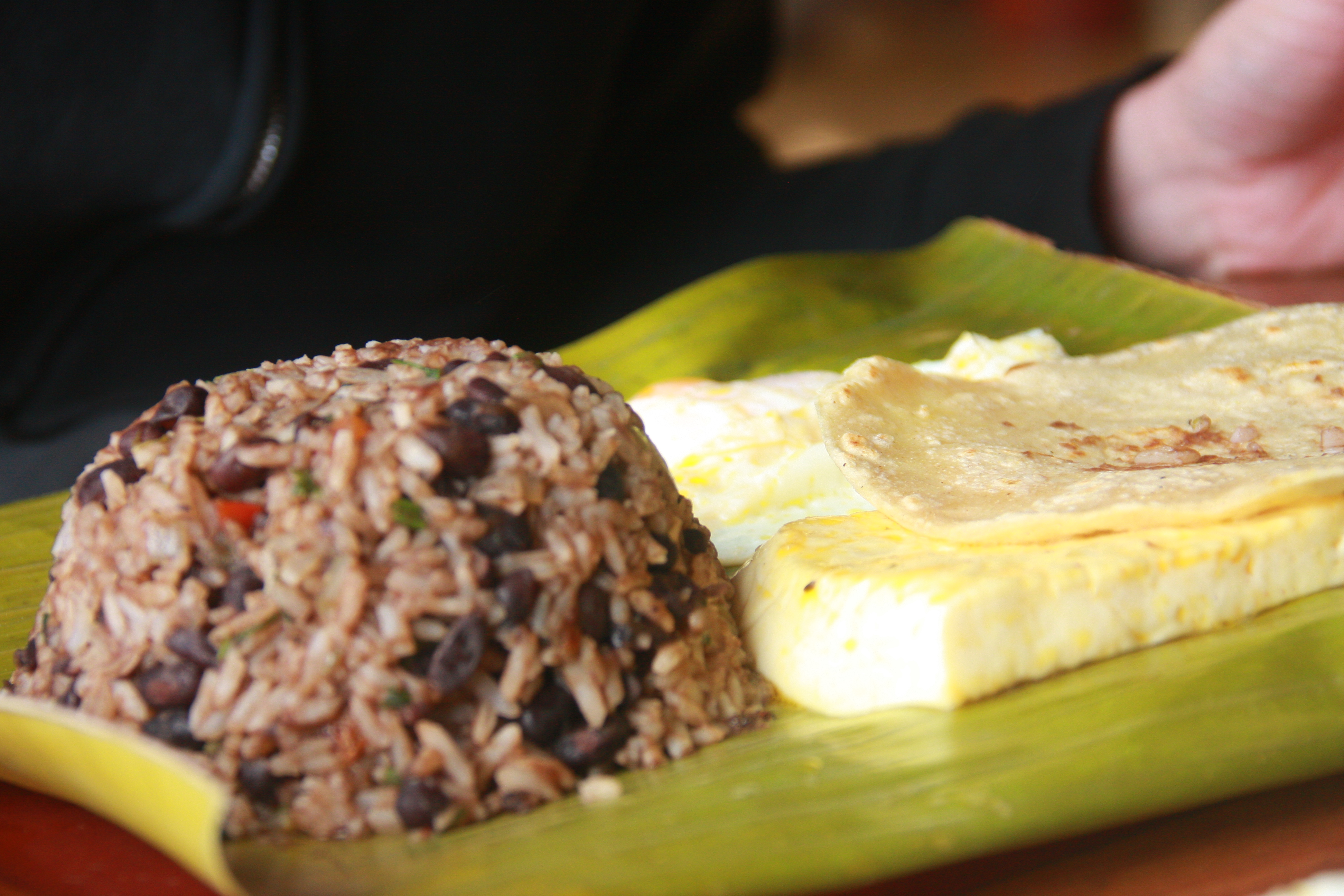 Gallo pinto served on banana leaf with fried egg and tortilla